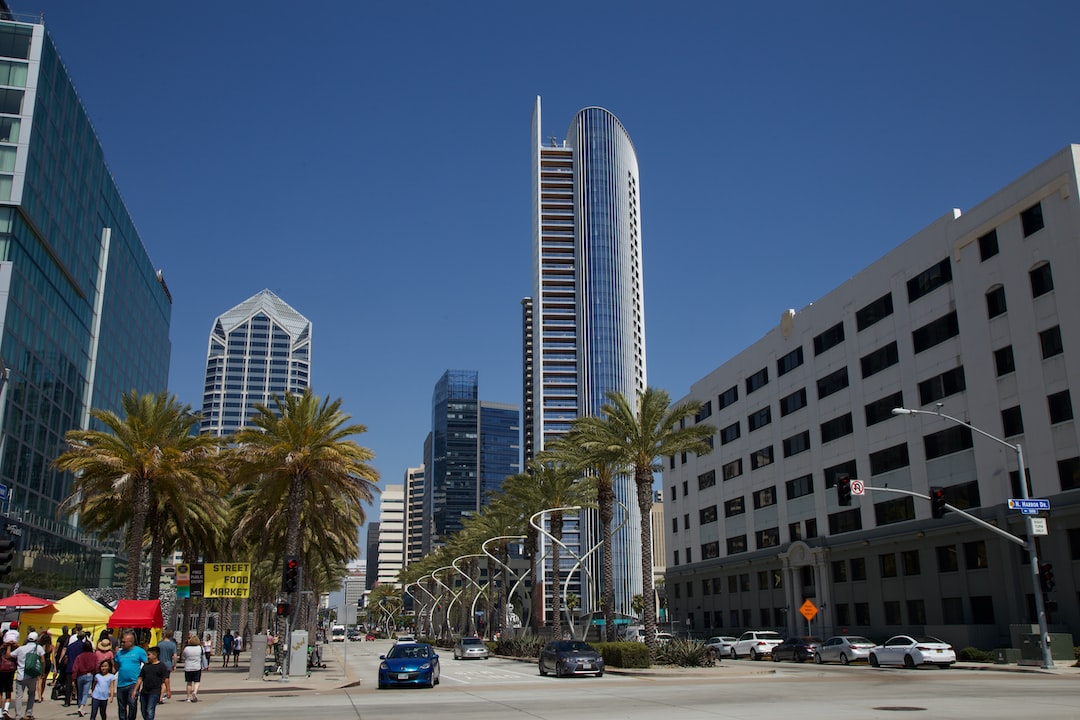 cars parked on parking lot near high rise buildings during daytime