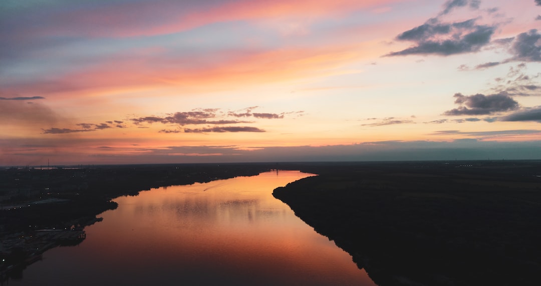 a sunset over a body of water with clouds in the sky
