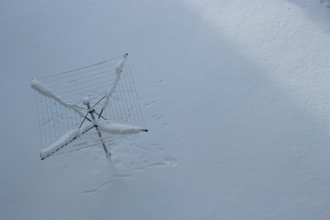 white satellite antenna covered by white snow on roof