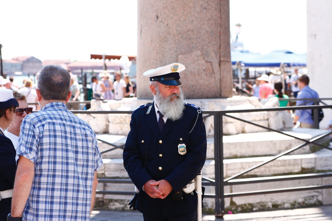 man in black police uniform standing beside brown concrete wall during daytime