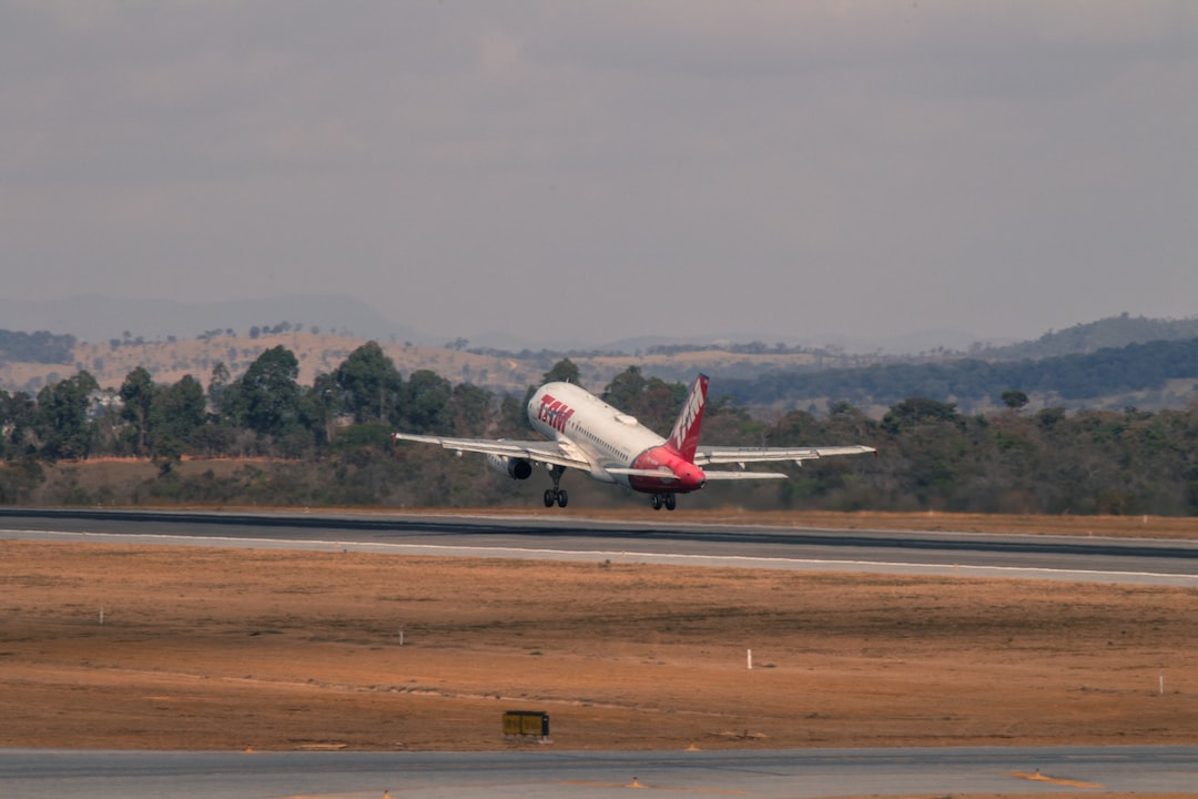 white and red airplane in a runway