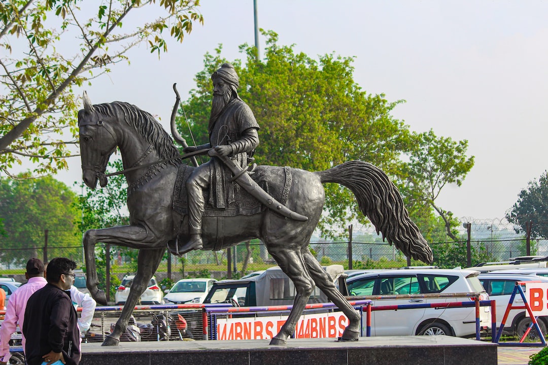 a statue of a man riding a horse in a parking lot