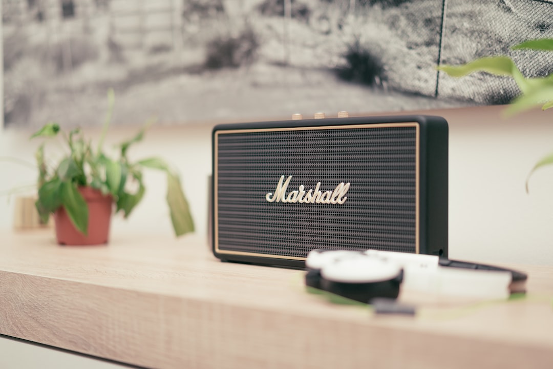 black Marshall Bluetooth speaker on top of brown table