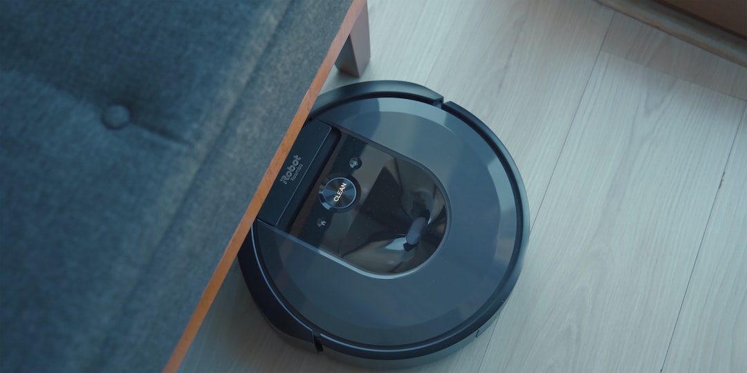 a robotic vacuum is on the floor next to a couch
