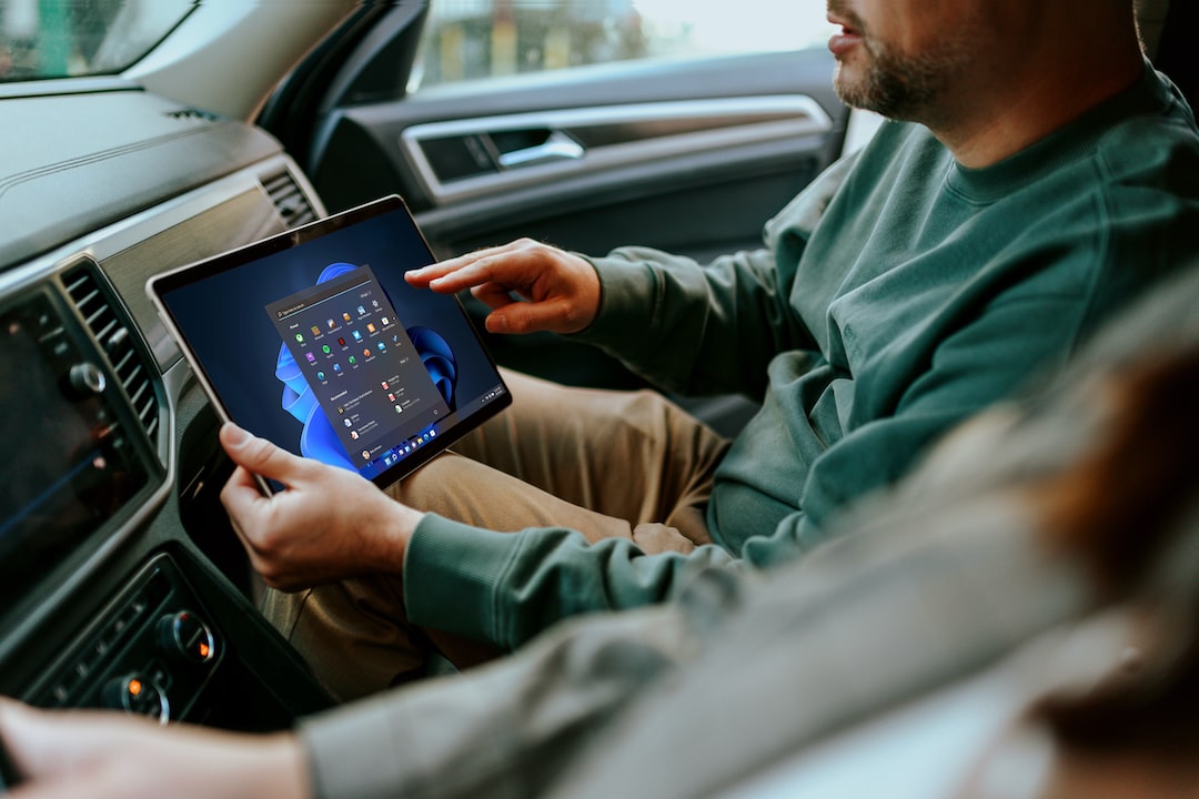 a man sitting in a car holding a tablet