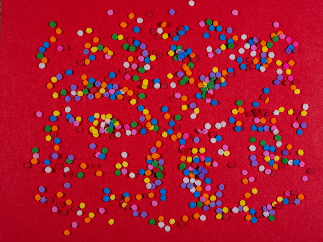 a red background with multicolored confetti sprinkles