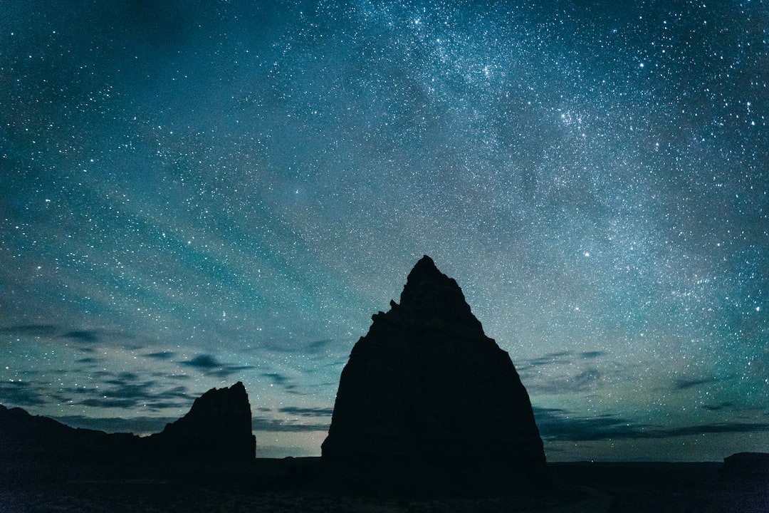 silhouette of rocky mountain under starry sky
