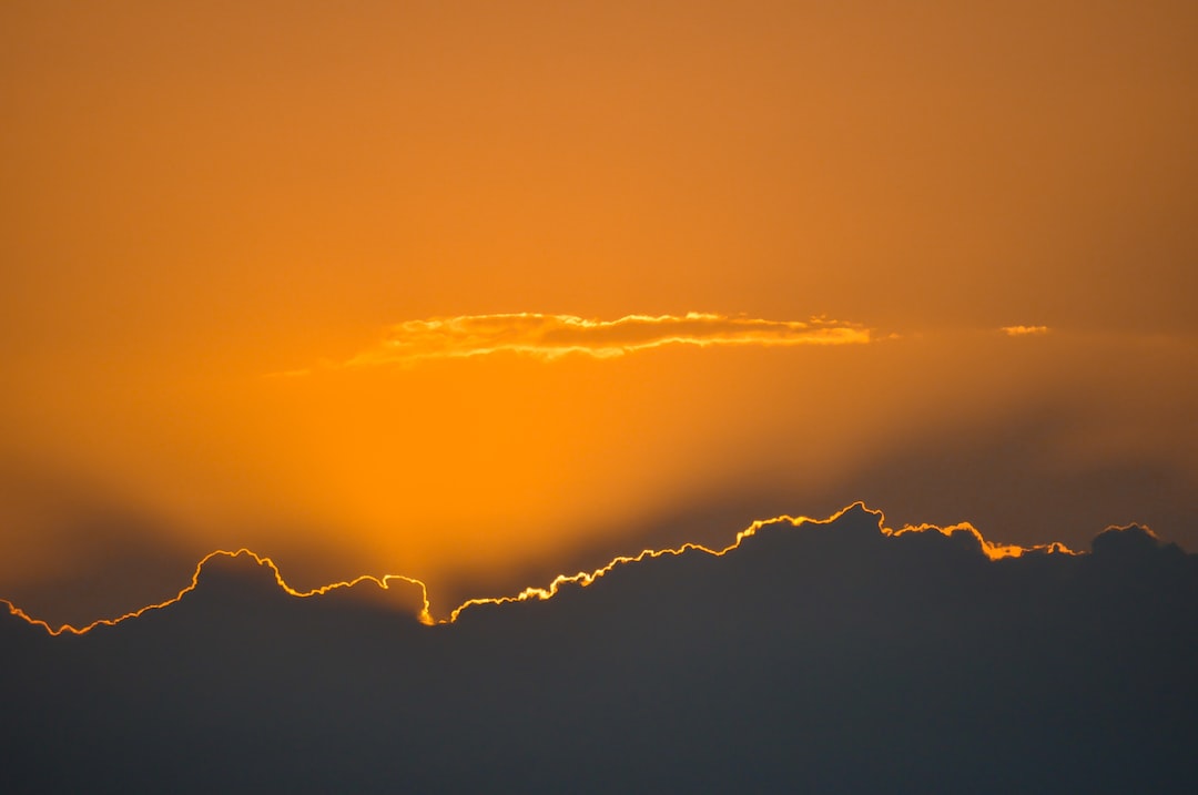 the sun is setting behind the clouds in the sky