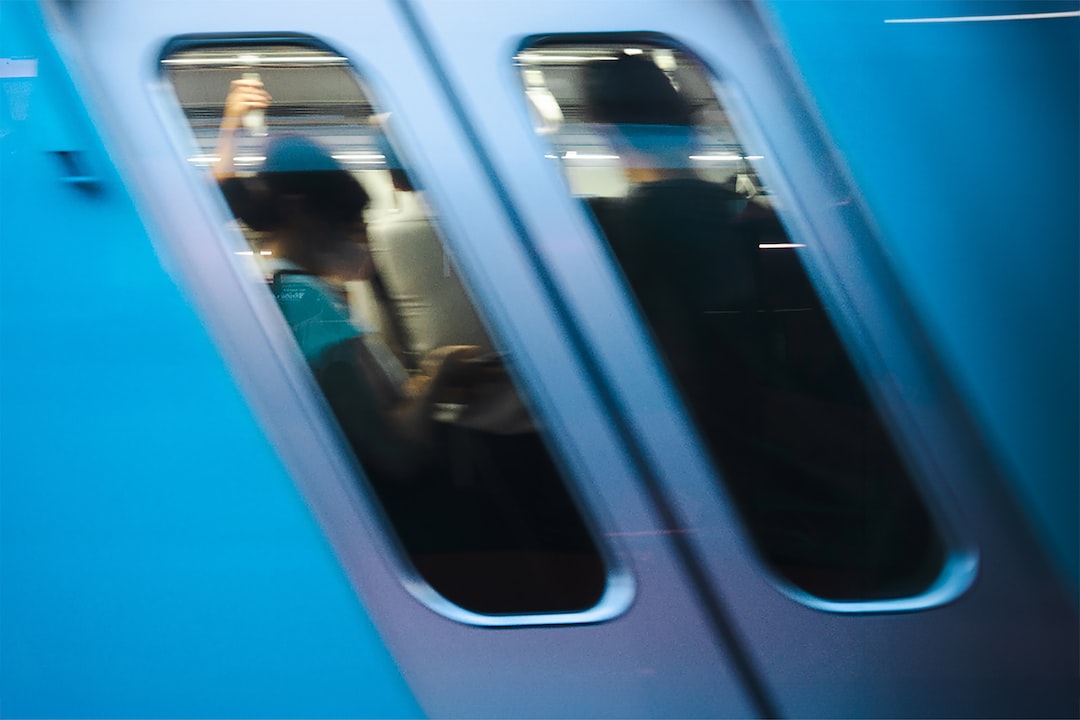 a man standing on a train looking out the window