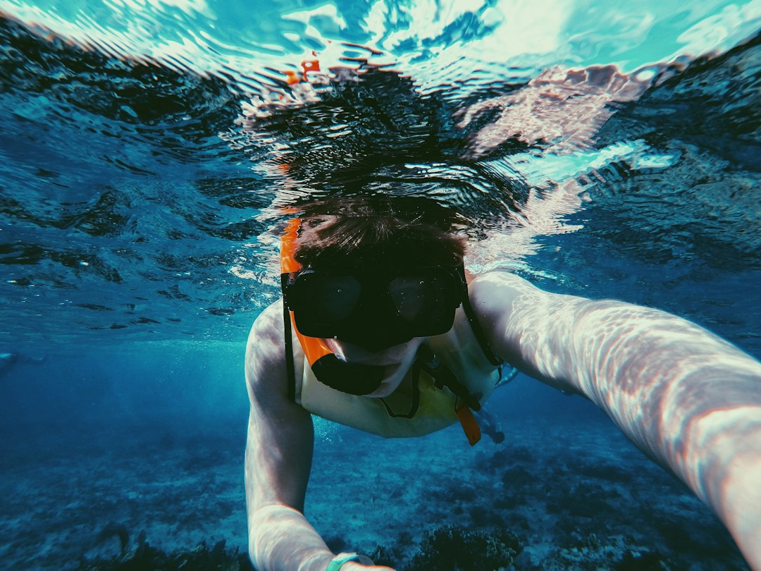 underwater photo of person wearing diving goggles and snorkel