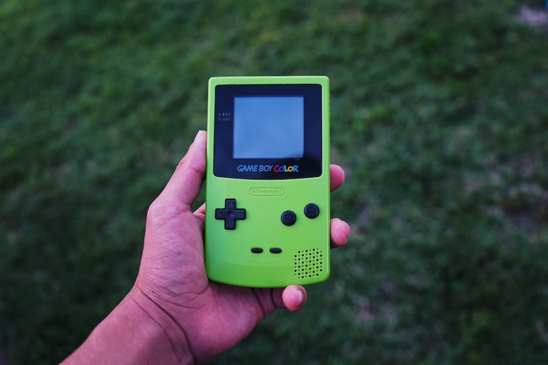 person holding a green Gameboy color console