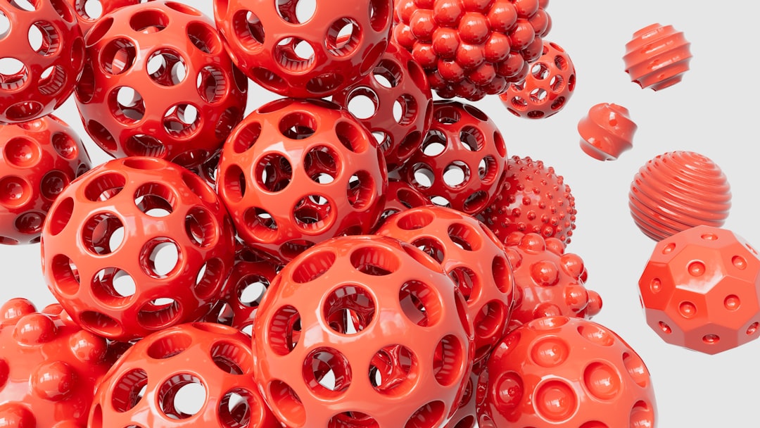 a pile of red plastic balls with holes on them