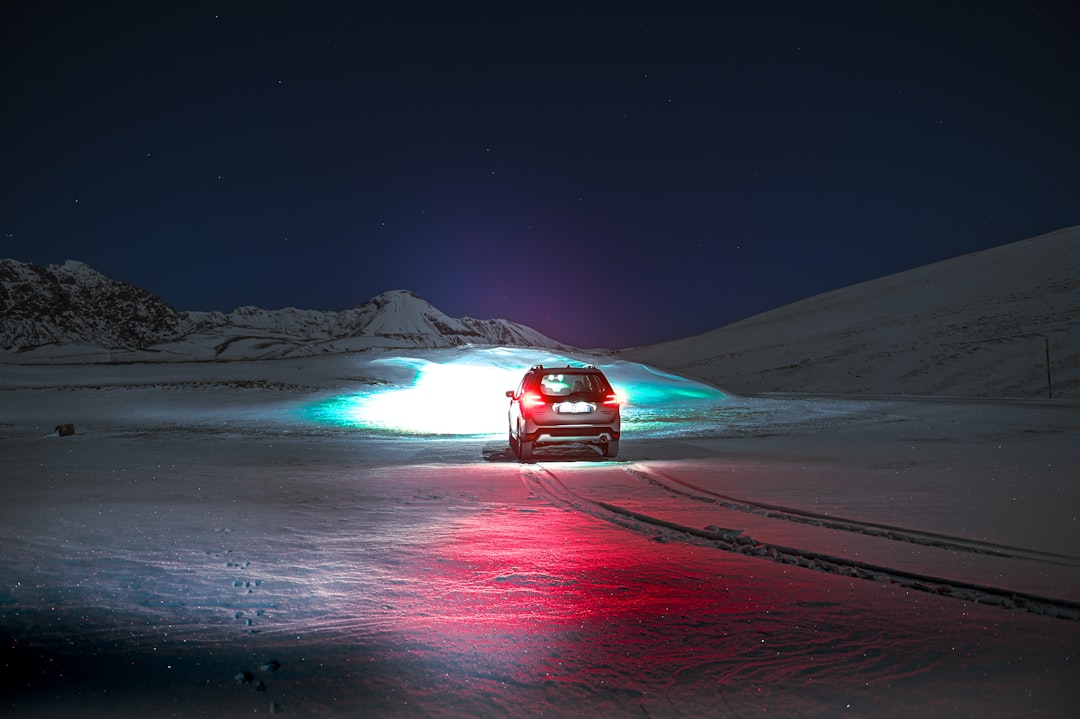 a car driving on a snowy road at night
