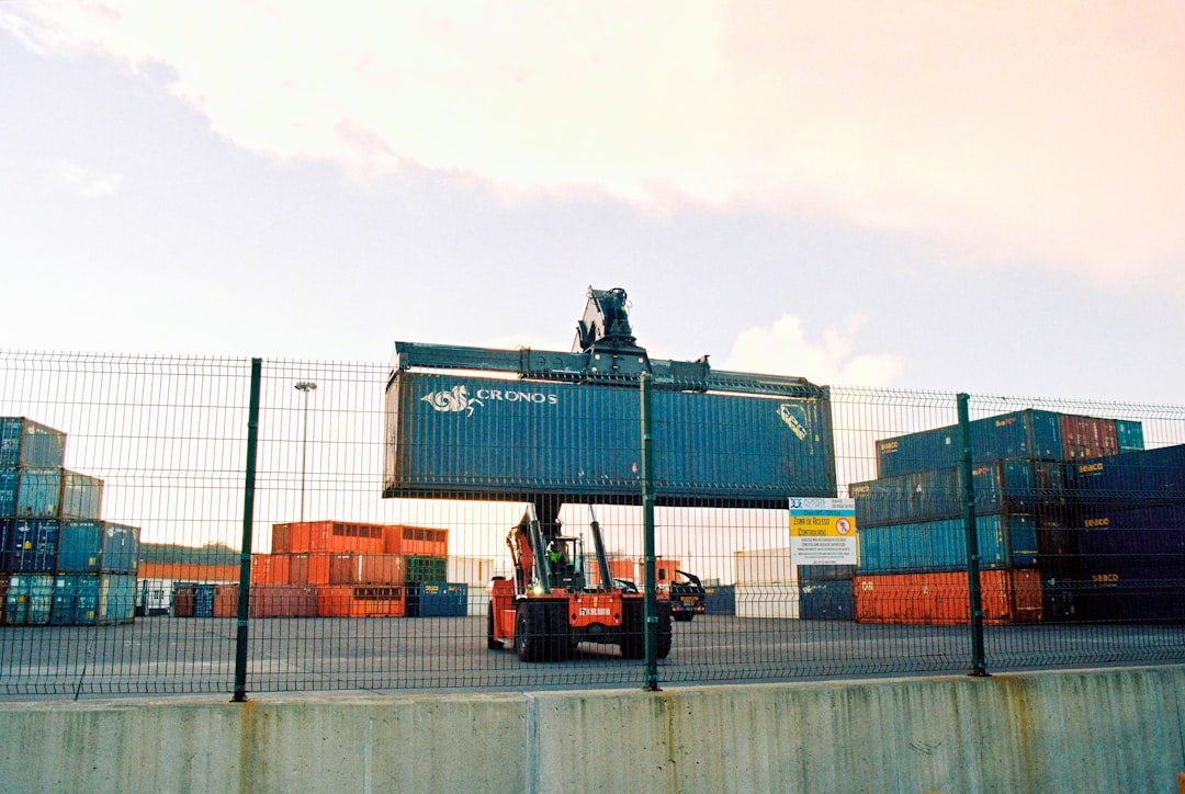 a forklift is moving a large container behind a fence