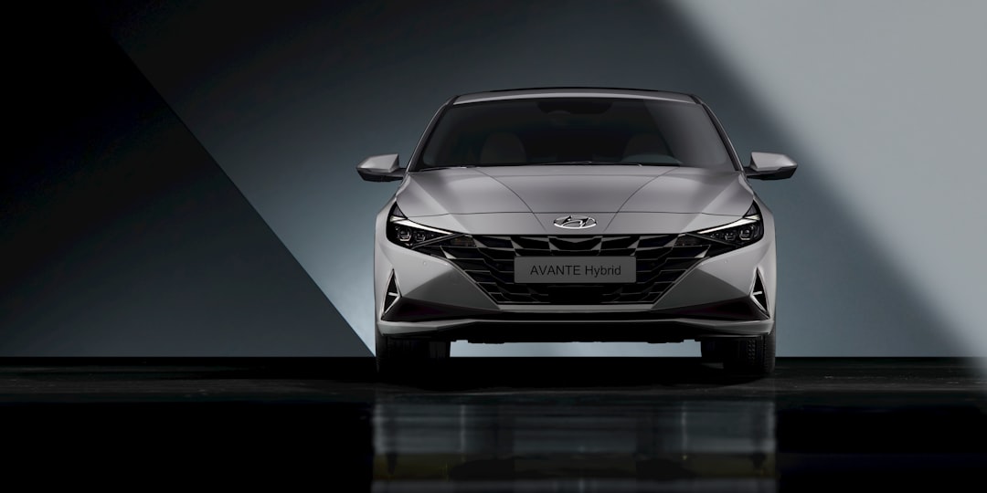 the front end of a silver car in a dark room