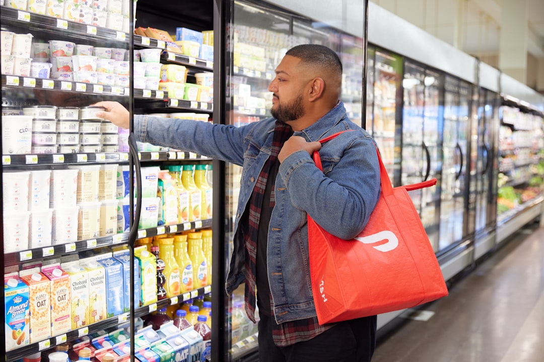 a man in a grocery store picking up a bag