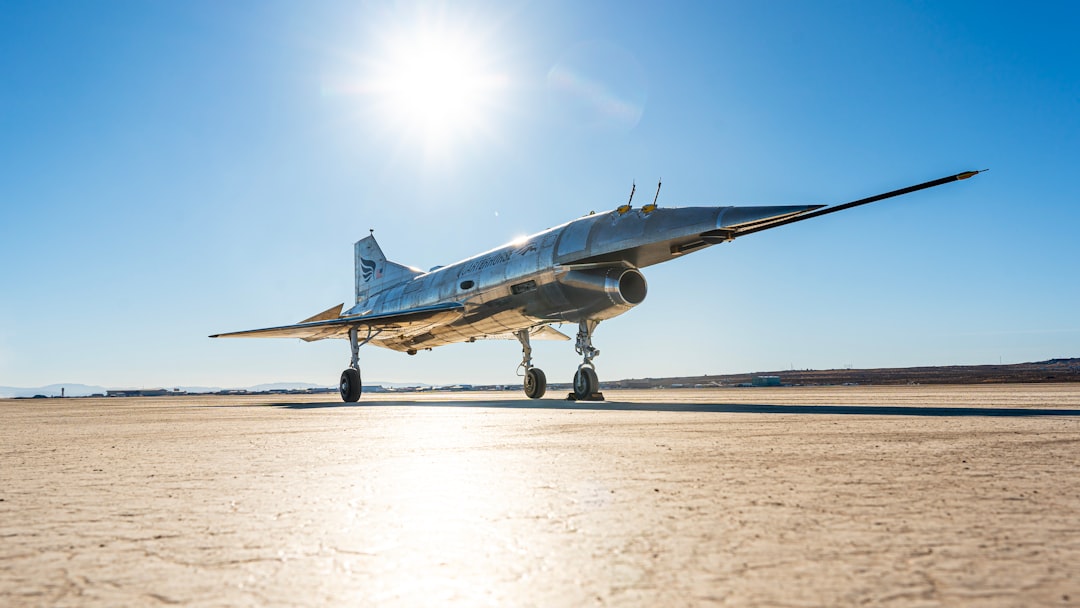 A silver jet sitting on top of an airport tarmac