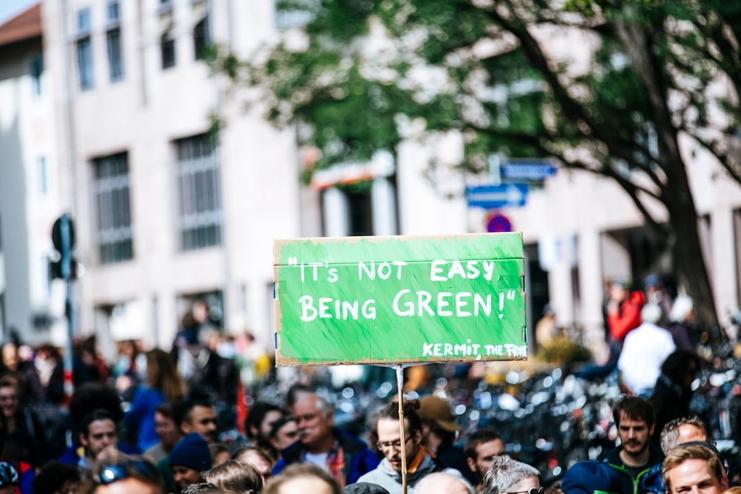 man holding a green board in a rally