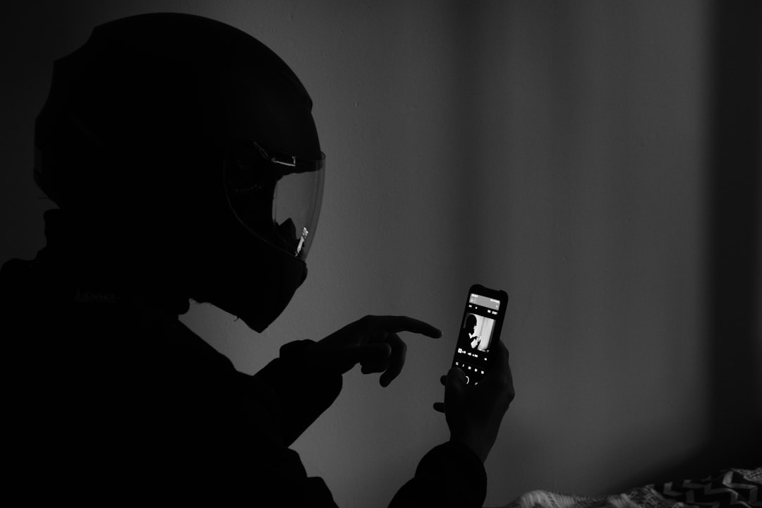 grayscale photography of man using smartphone