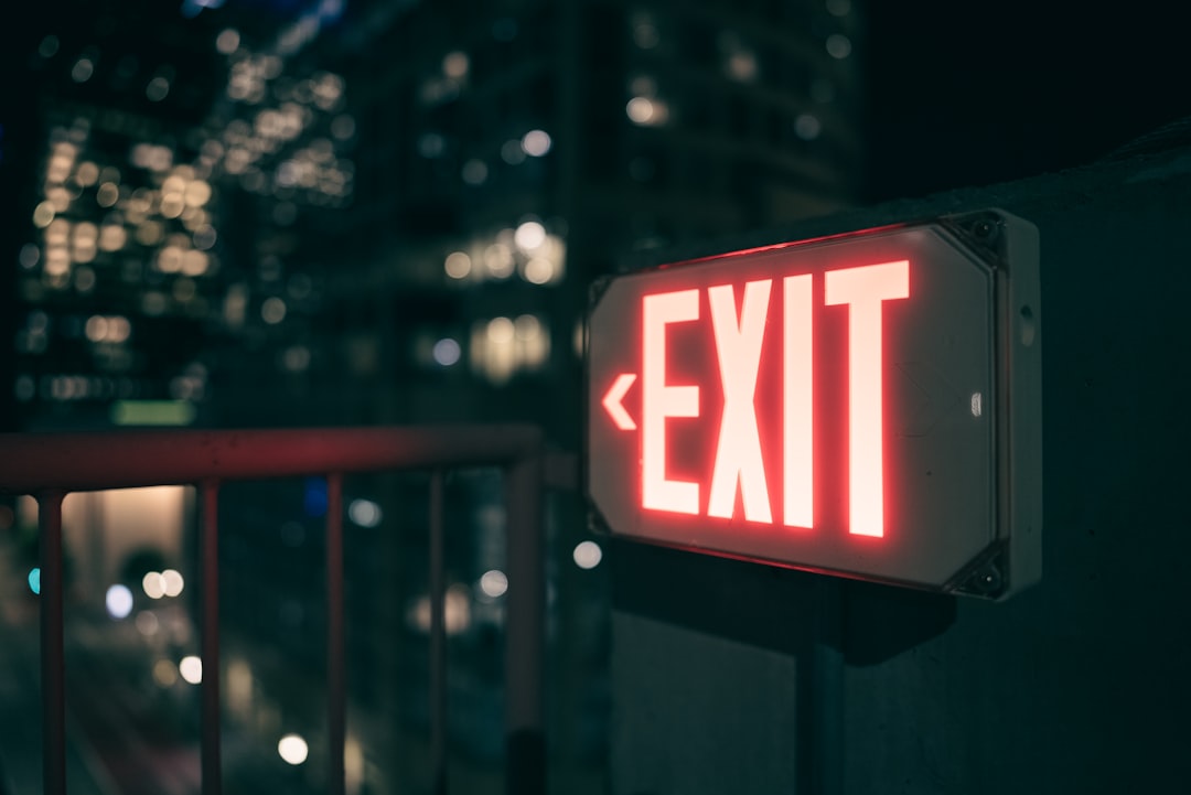 a red exit sign sitting on the side of a building