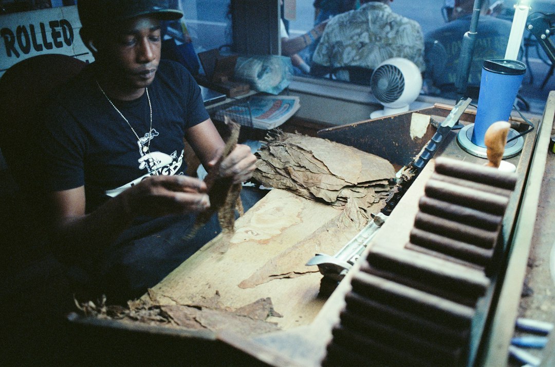 Man rolling cigars by hand with tobacco leaves